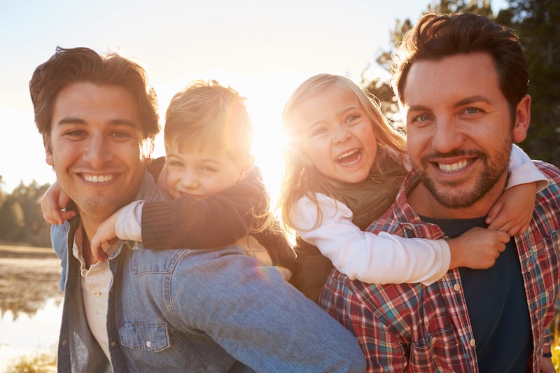 two men with two kids on their shoulders