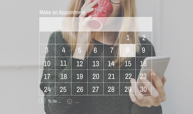 woman looking at her phone with calendar graphic overlayed