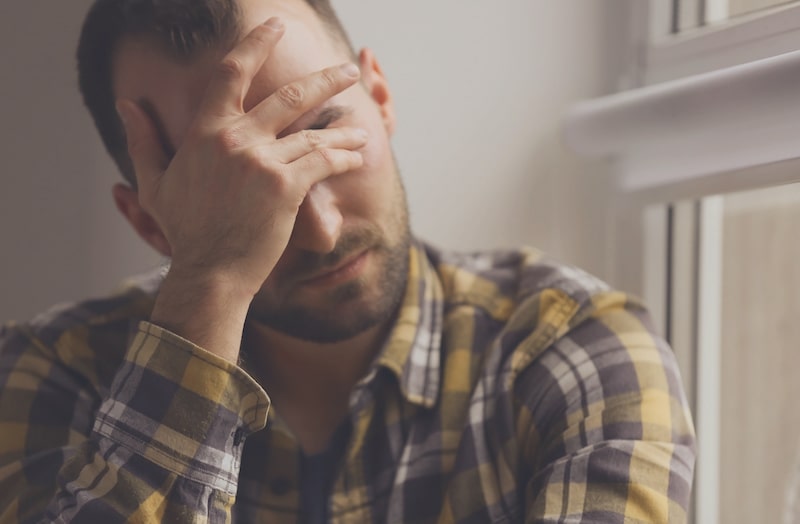 man with his hand to his face 