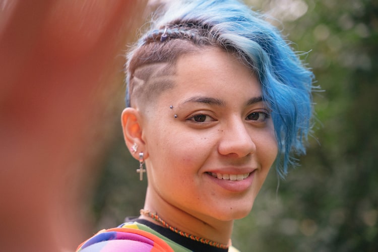 woman with blue hair smiling at the camera