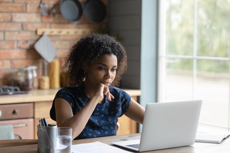 woman sitting and looking at her laptop