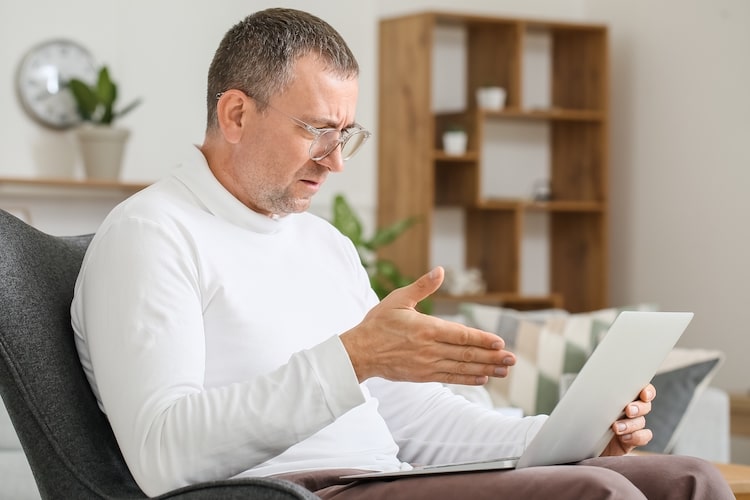 man talking to his computer and looking upset