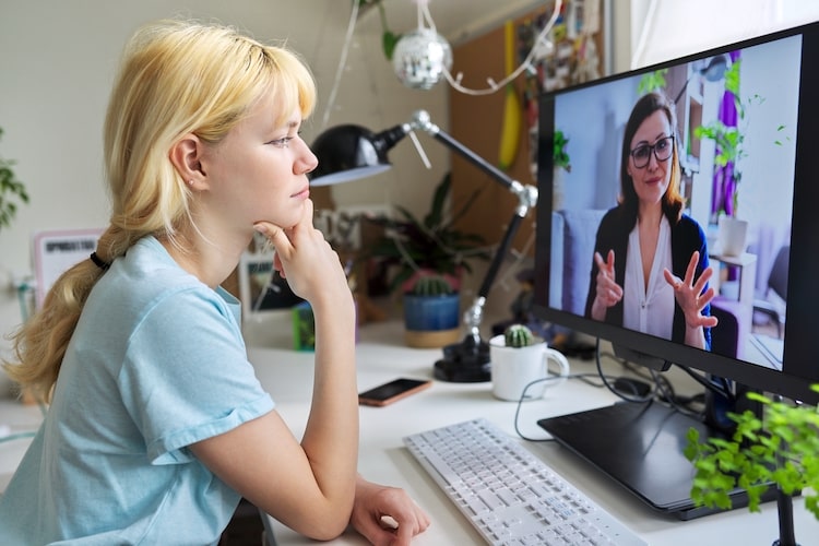 young girl looking at the computer talking to a doctor