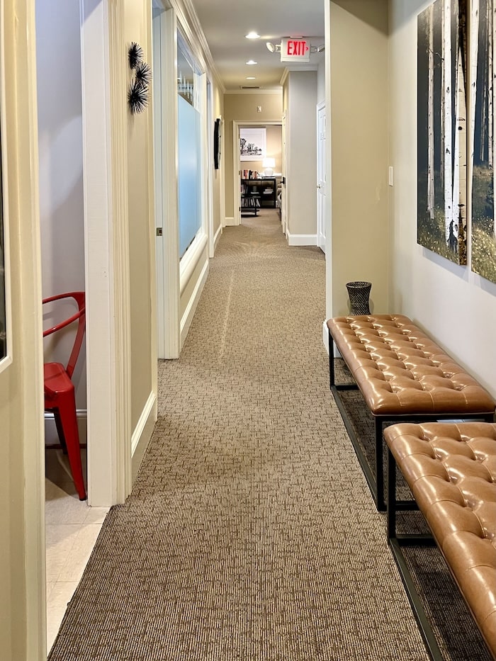 Long hallway with two light brown, cushioned, leather benches